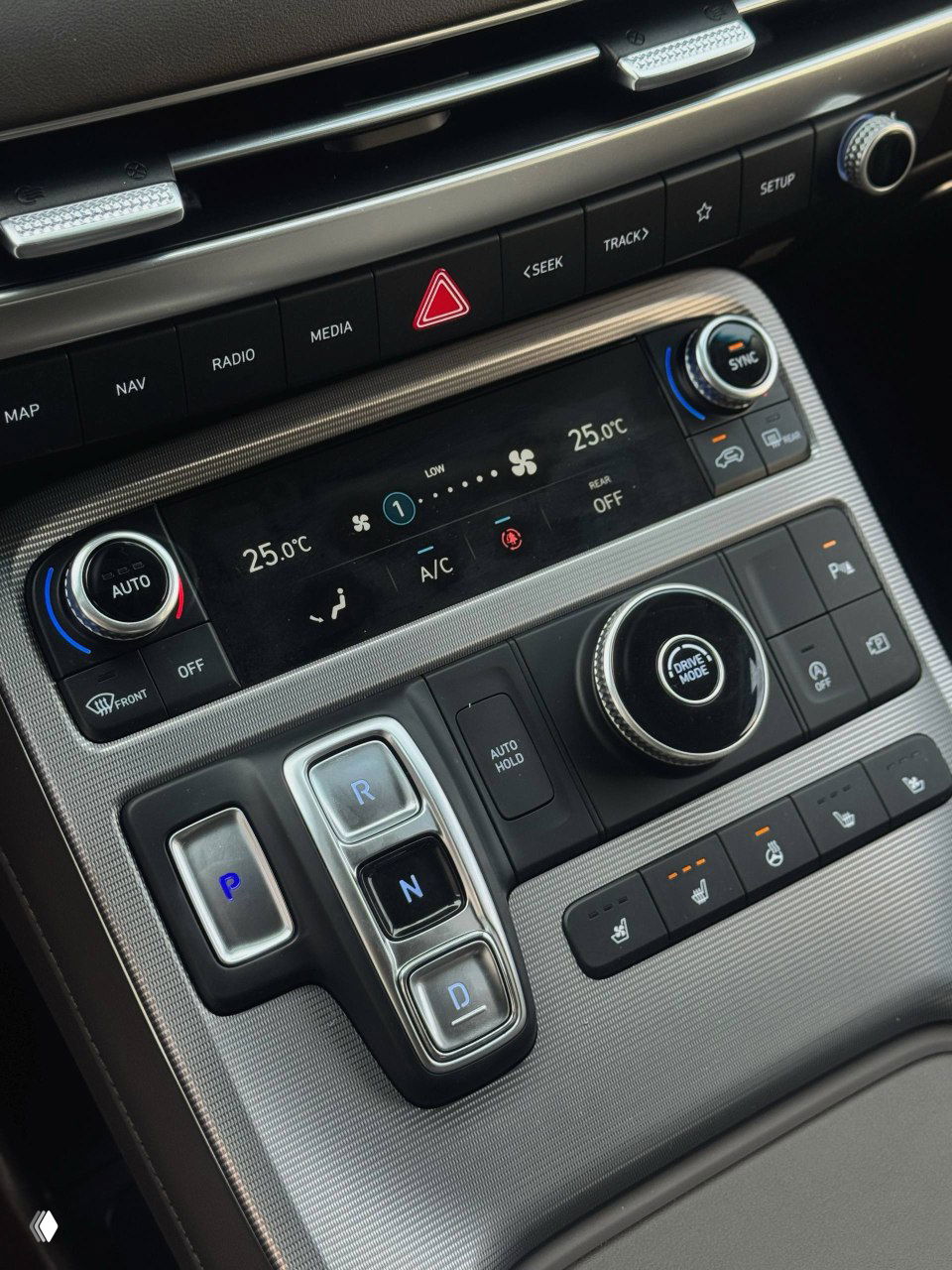 Крупный план блока управления климатом и кнопок управления трансмиссией на центральной консоли, ручки и клавиши управления климатом Hyundai Palisade.
