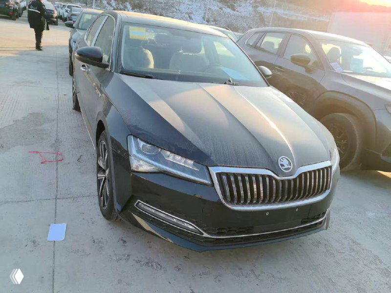 Чёрный Skoda Superb 2025, вид спереди с другой позиции на открытой площадке — кузов и фары видно в естественных условиях освещения.