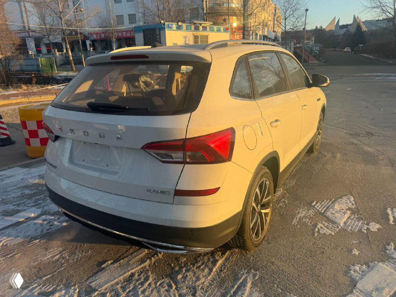 Задняя часть белого Skoda Kamiq 2025: багажник, фонари и задний бампер на зимней парковке, автомобиль без номерного знака.