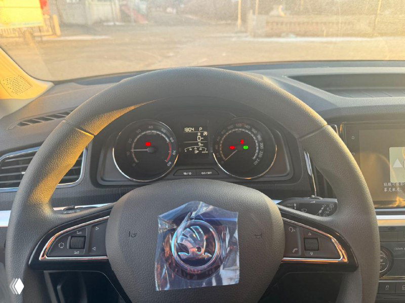 Салон Skoda Kamiq — вид на рулевое колесо и панель приборов, рулевое колесо с защитной пленкой, видна центральная консоль и частично приборная панель.