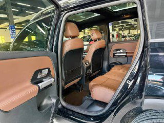 Задние сиденья Mercedes GLB 180 2022 в коричневой коже; пространство для пассажиров, подголовники и вид на пол и передние кресла из салона.