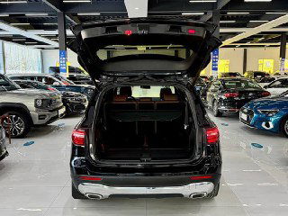 Открытый багажник Mercedes GLB 180 2022: большой грузовой отсек с ровным полом, вид на внутреннее пространство и заднюю сторону автомобиля в салоне дилера.