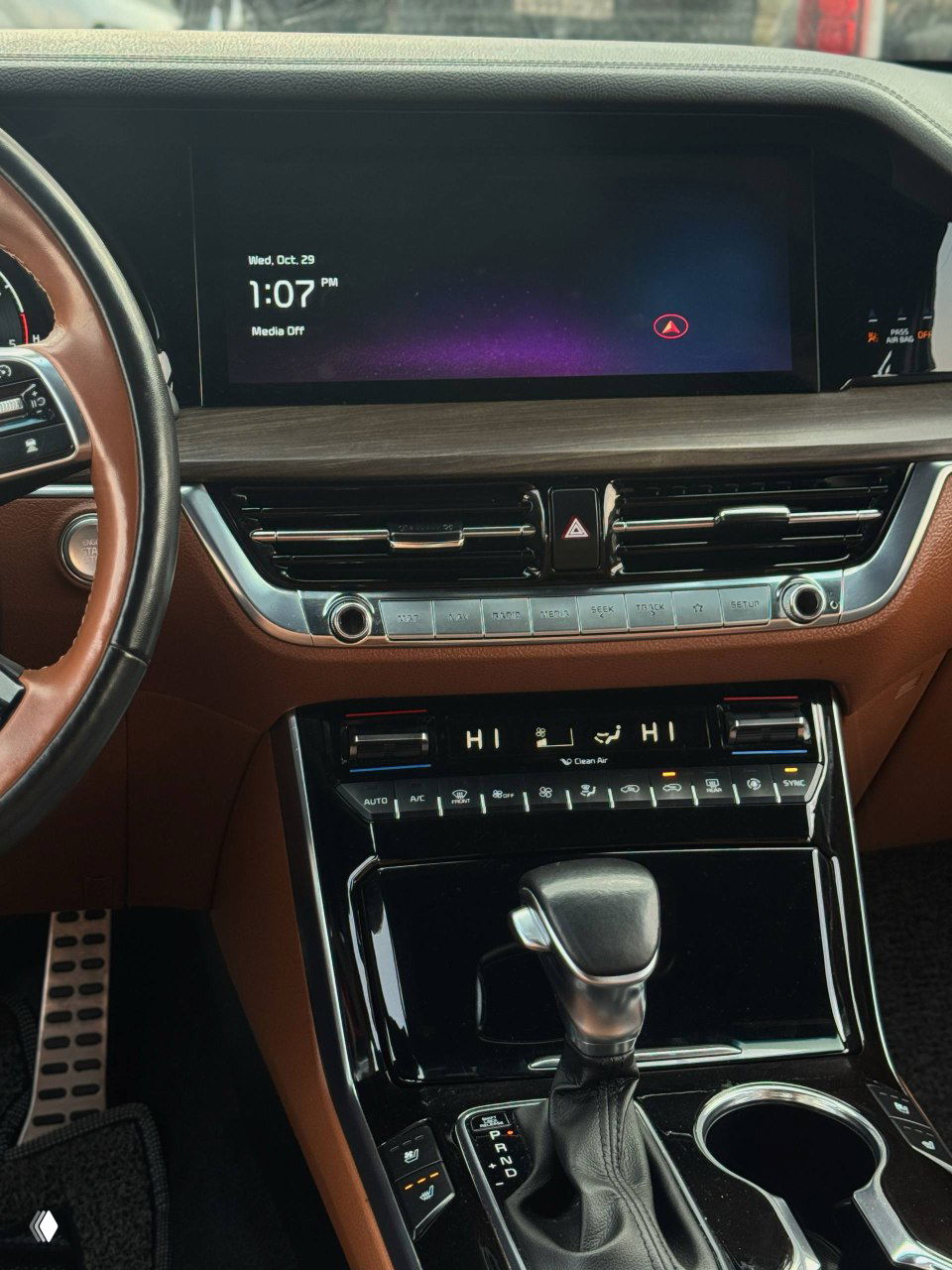 Широкий дисплей мультимедийной системы и центральная консоль KIA Mohave, видны вентиляционные решётки и селектор коробки передач.