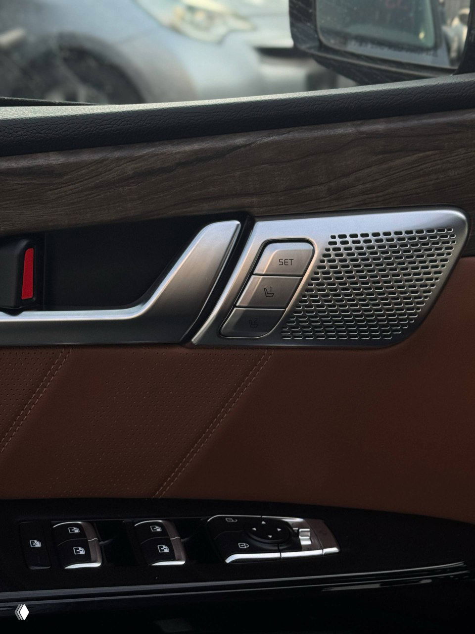 Дверная панель KIA Mohave с декоративной вставкой под дерево, кнопками памяти сидений, регулировками и динамиком штатной аудиосистемы.