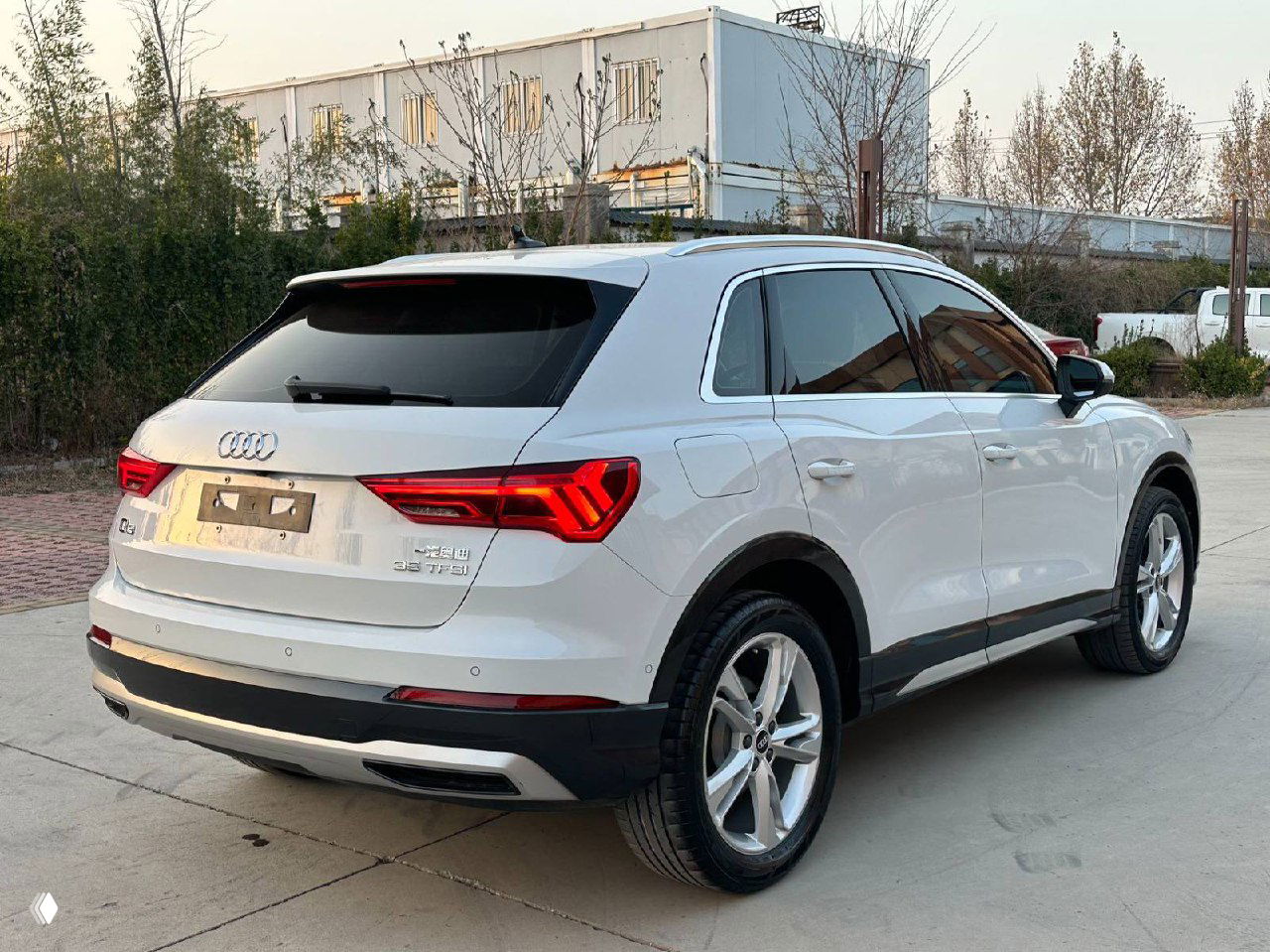 Белый Audi Q3 35TFSI, вид сзади-слева на бетонной площадке; видны задние фары, бампер и багажник, предназначено для оценки состояния при удалённом осмотре.