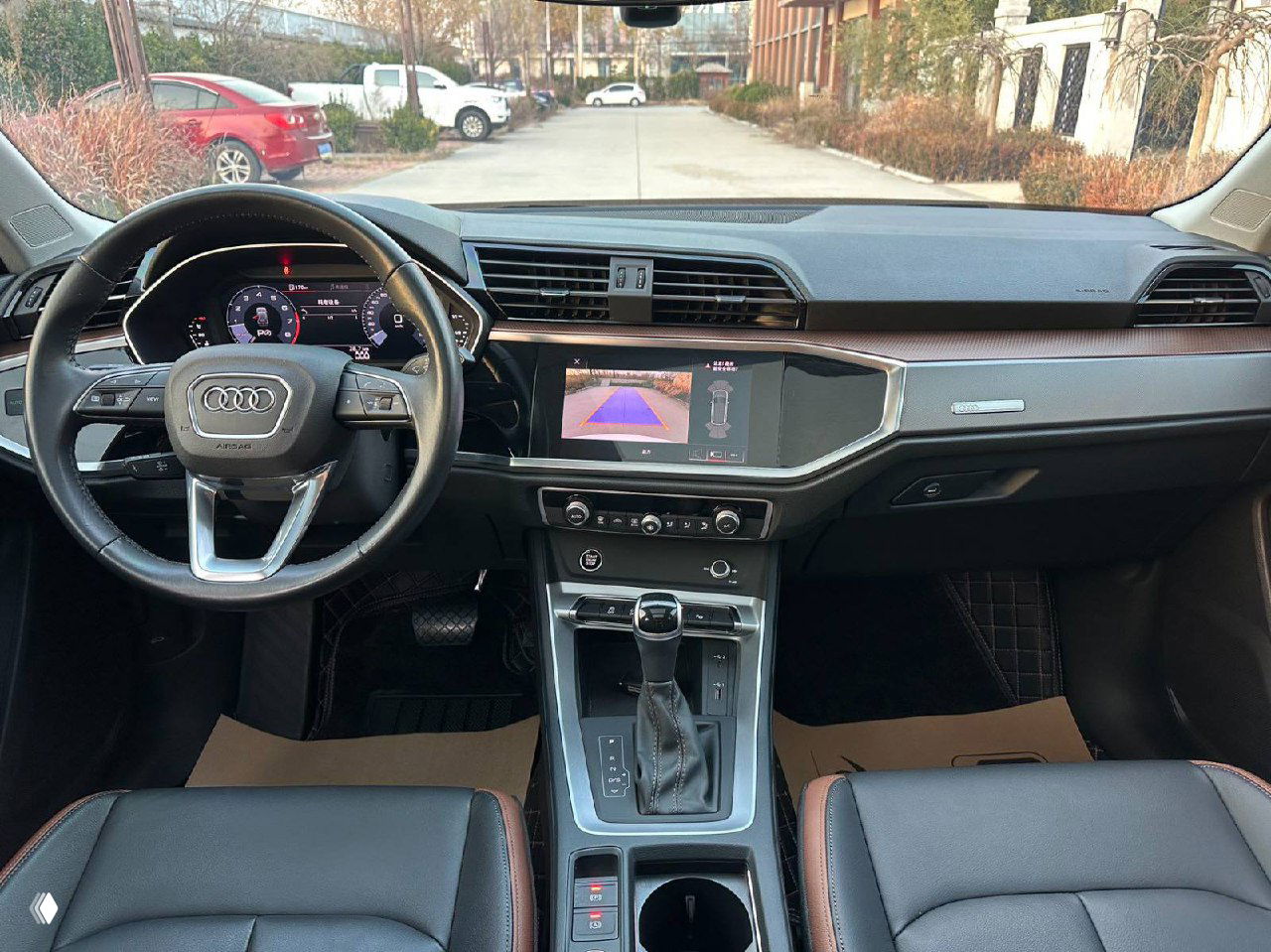 Вид торпедо и центральной панели Audi Q3: мультимедиа экран, рулевое колесо и центральная консоль видны чётко; полезно для оценки комплектации салона при осмотре.