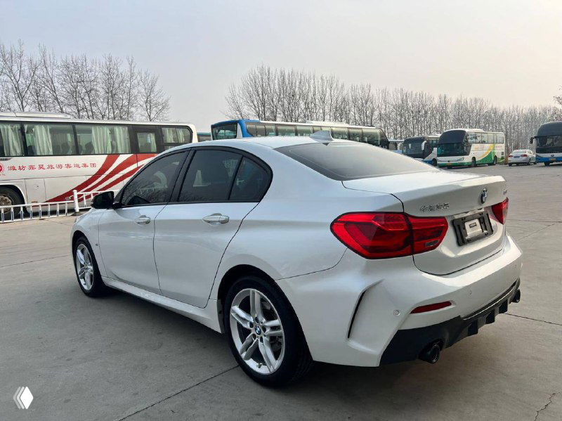 Задний ракурс белого BMW 1‑Series (120i) 2021 на парковке, вид на багажник и фонари, состояние лакокрасочного покрытия хорошо видно.