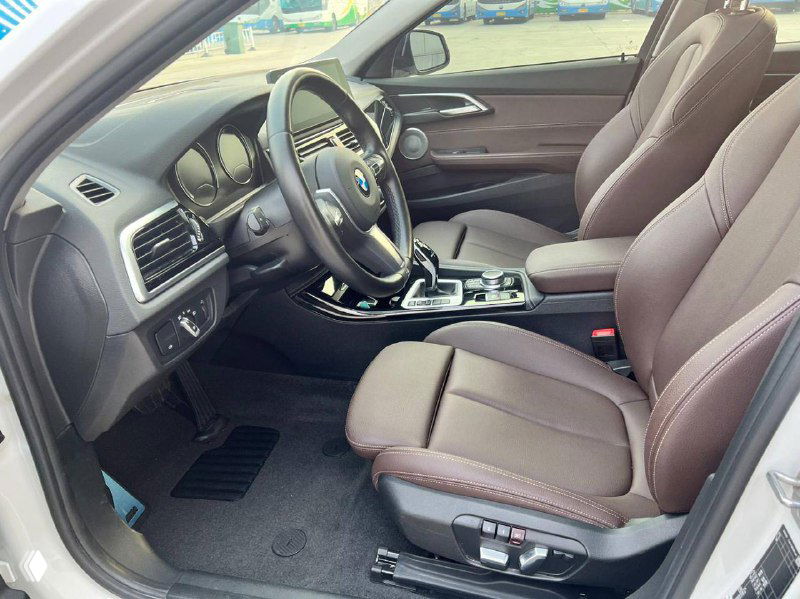 Интерьер BMW 120i, передние сиденья с коричневой обивкой, вид руля и центральной части салона, демонстрация состояния кресел и регулировок.