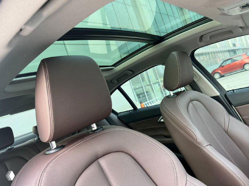 Вид на панорамный люк и потолок салона BMW 120i, передние подголовники и часть обивки крыши, демонстрация опции люка и состояния электрических элементов.