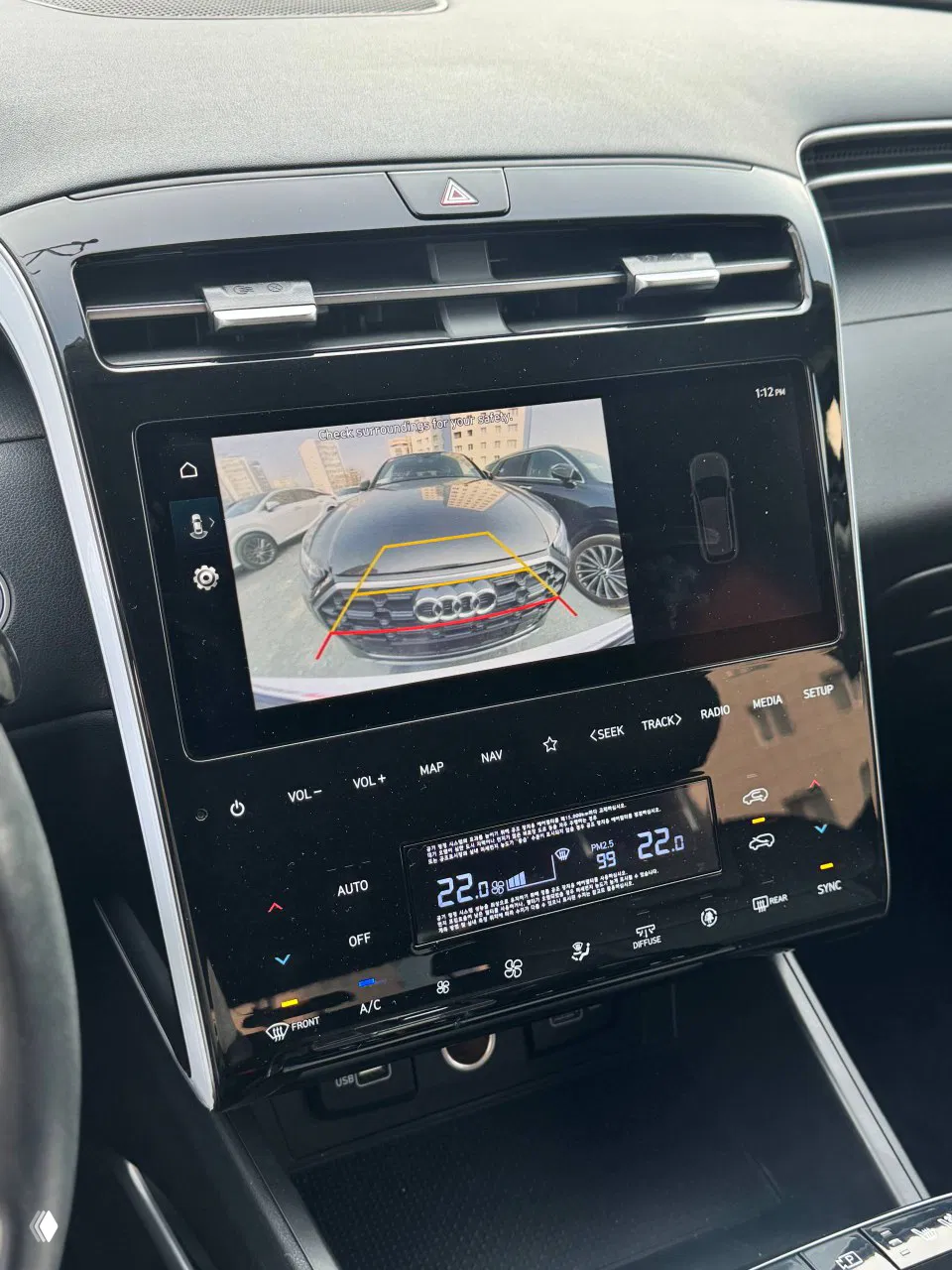 Экран мультимедиа с изображением камеры заднего вида и интерфейсом парковки, внизу видна панель климат‑контроля и индикаторы температуры.