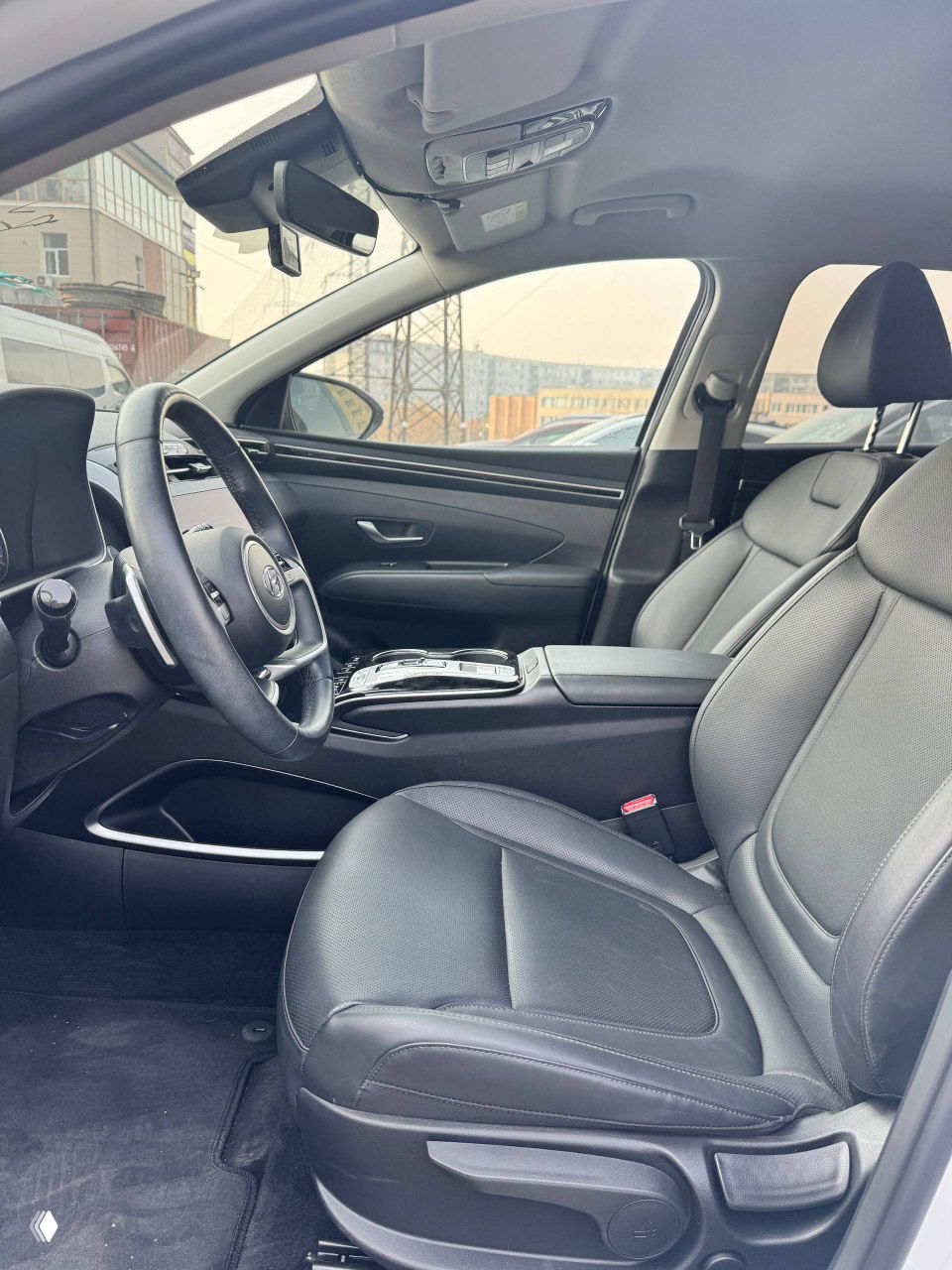 Переднее пассажирское кресло Hyundai Tucson, вид на салон: кожаная обивка, подлокотник и панель двери, хорошее состояние интерьера.