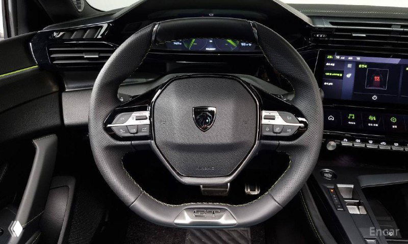 Рулевое колесо и передняя панель Peugeot 408: крупный план руля с элементами управления и частью цифровой приборной панели.