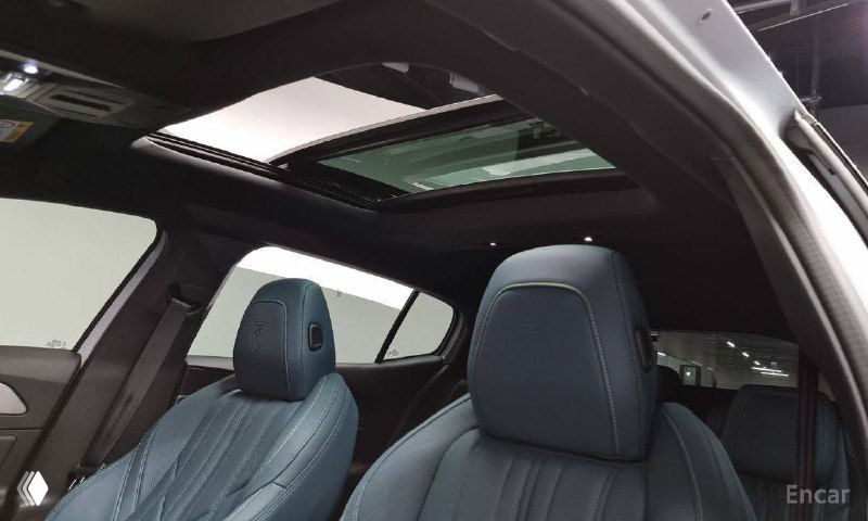 Люк и передние кресла Peugeot 408: панорамный люк в сочетании с голубой кожаной отделкой сидений, вид сверху на салон автомобиля.