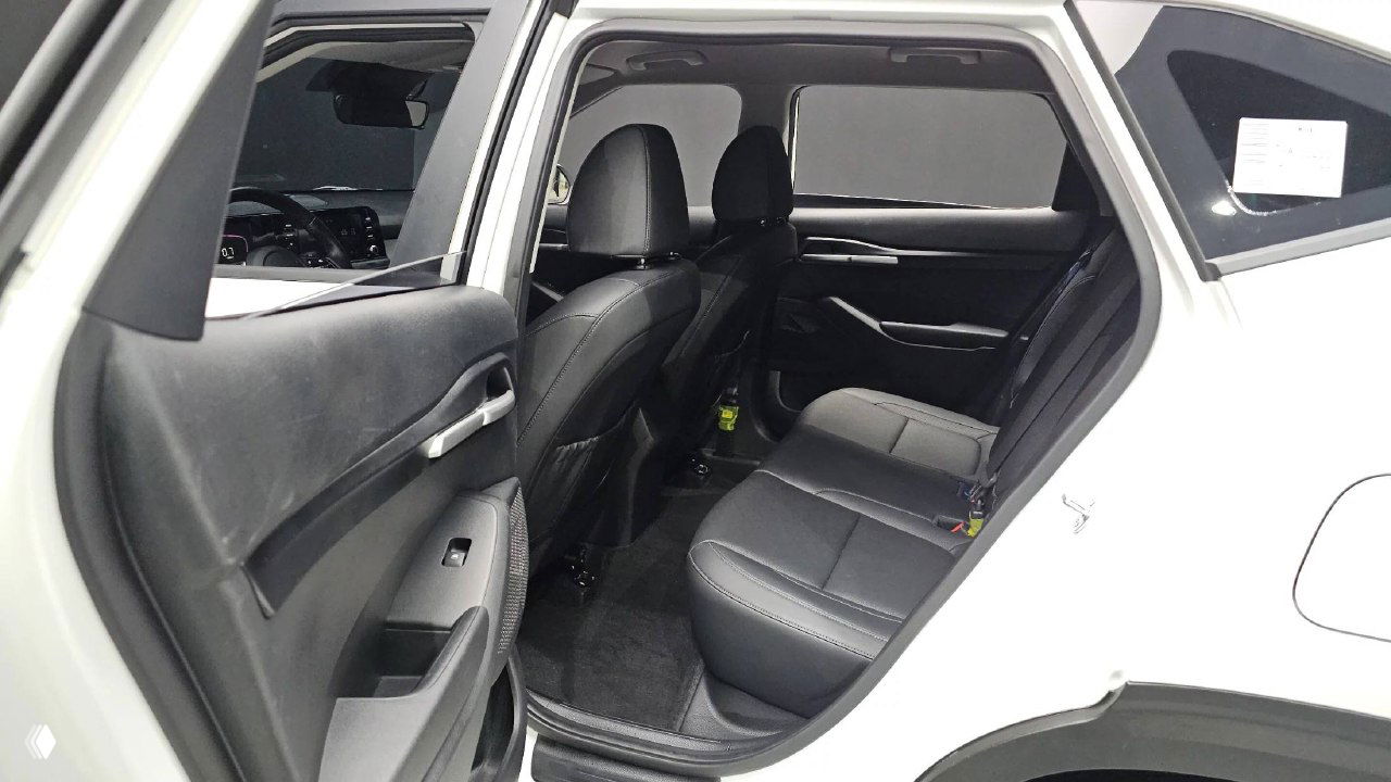 Задний ряд KIA Seltos 2023: вид на задние сиденья, дверные проемы и пространство для пассажиров на втором ряду автомобиля белого цвета.