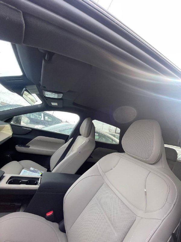 Потолок и передние сиденья Volvo XC-70 2025 при дневном свете, видны поручни, отделка и общий вид внутреннего убранства для потенциальных покупателей.