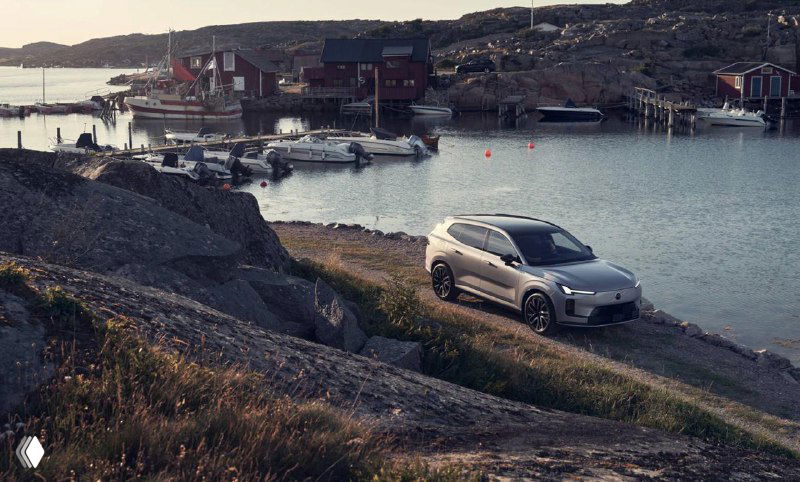 Автомобиль Volvo припаркован у побережья на фоне скал и воды, подчёркивая внедорожный характер и универсальность модели для путешествий.