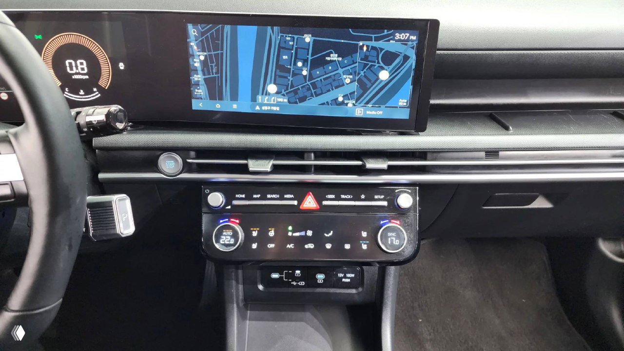 Крупный план центральной консоли и информационно-развлекательного экрана Hyundai Tucson с отображением карты и элементами управления климатом и мультимедиа.