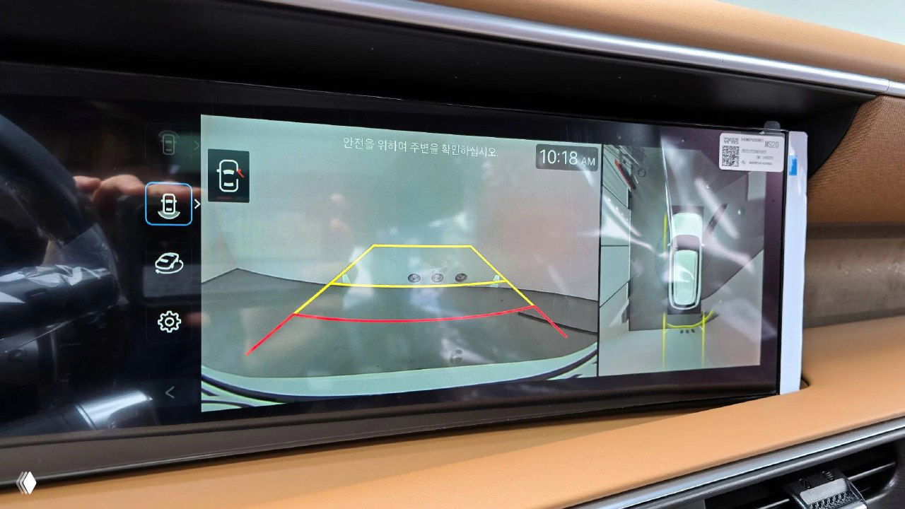 Широкоформатный центральный дисплей Hyundai Palisade показывает изображение камеры заднего вида и обзор 360°, элементы интерфейса видны крупно.