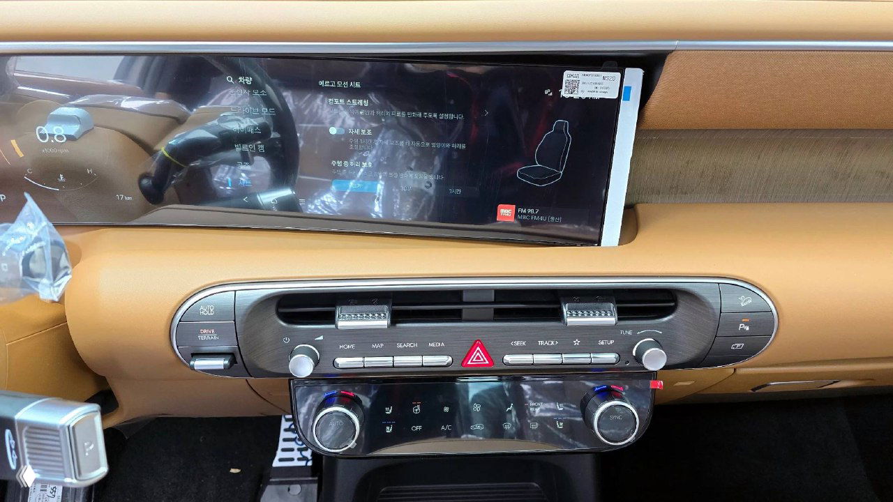 Панель управления и климат-контроль Hyundai Palisade, коричневый декоративный декор, кнопки управления и регуляторы видны крупным планом.