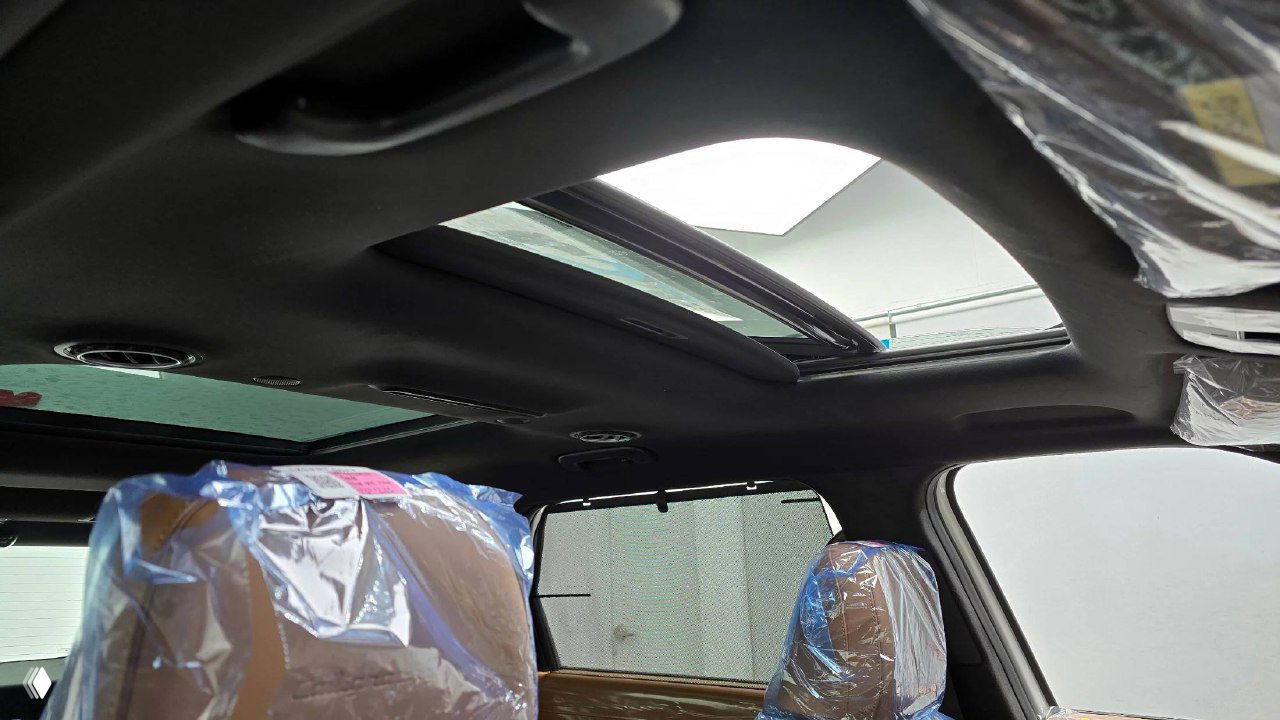 Панорамная крыша и люк Hyundai Palisade, вид внутри салона с защитной плёнкой на сиденьях и верхней частью интерьера.