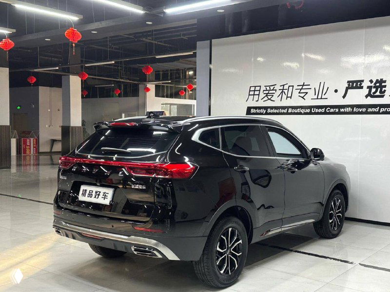 Задняя часть чёрного Haval H6 в шоуруме, видны фонари, багажная дверь и общие габариты кроссовера на фоне стенда.