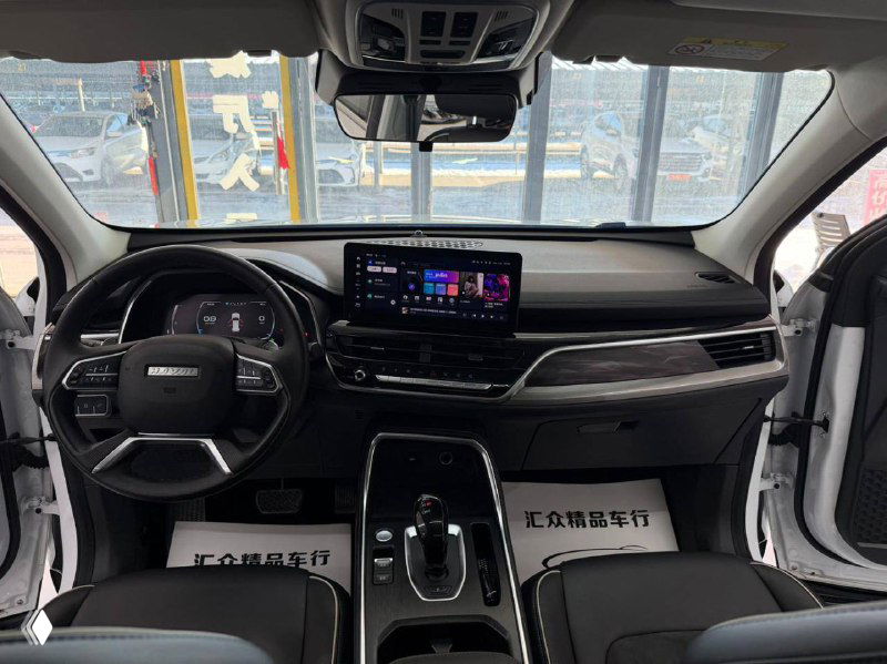 Передняя панель и центральная консоль Haval H6: мультимедийный экран, климат-контроль и руль в интерьере белого кроссовера