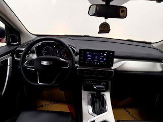 Салон Geely Coolray 2025, вид на панель приборов и центральный сенсорный экран; руль, приборная панель и элементы управления мультимедиа хорошо различимы.