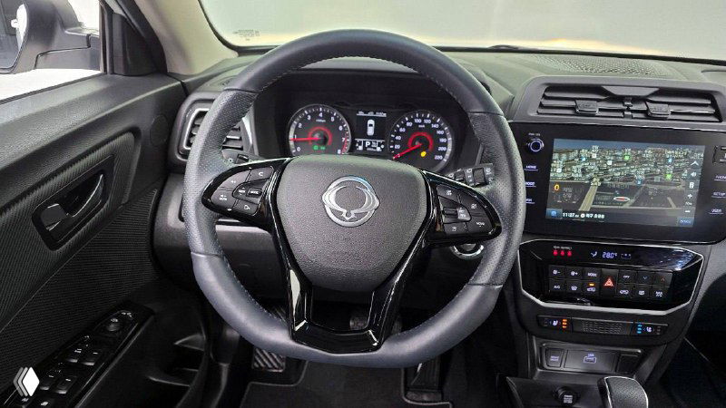 Рулевое колесо и центральная консоль SsangYong Tivoli с кнопками управления и экраном; крупный план для оценки функционала и износа