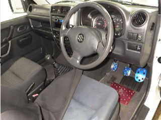 Салон Suzuki Jimny 2011: панель приборов, рулевое колесо и механическая КПП; фото показывает состояние салона и аксессуары.
