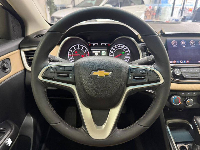 Салонная панель и рулевое колесо Chevrolet Cruze с логотипом Chevrolet, вид на приборную панель и центральную консоль в рабочем состоянии.