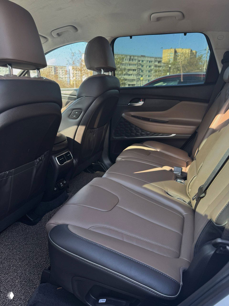 Ракурс салона Hyundai: водительское место, передняя панель и часть центральной консоли в естественном освещении на парковке.