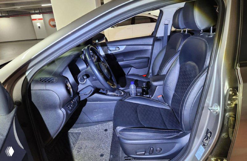 Интерьер KIA K3 — передние сиденья, торпедо и дверь водителя, видна отделка салона и регулировки сиденья для оценки состояния.