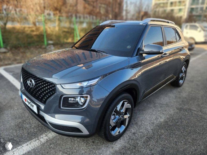 Серый Hyundai Venue 2025 года на открытой парковке, общий вид кузова и дизайн передней части автомобиля для осмотра перед покупкой.