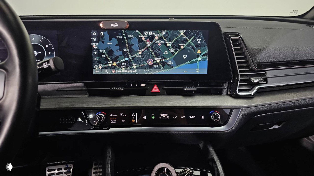 Центральная панель KIA Sportage: широкий мультимедийный дисплей с навигацией, климат-контроль и декоративные вставки — видно расположение органов управления.