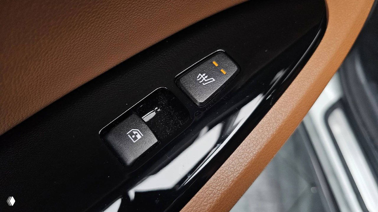 Детальный крупный план блока управления стеклоподъёмниками и кнопки подогрева на дверной панели KIA Sportage, видна текстура отделки и переключатели.