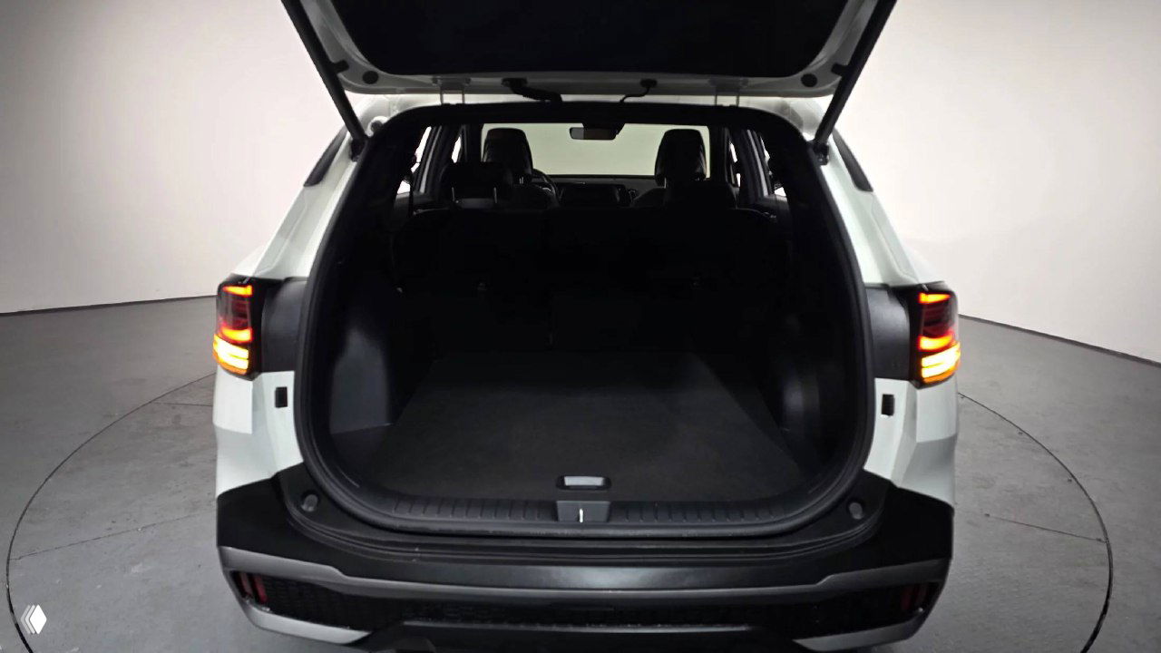 Открытый багажник белого KIA Sportage 2024, пустое грузовое пространство с ровным полом и облицовкой багажного отсека — виден объём и проём загрузки.