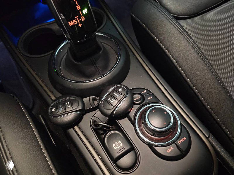 Фрагмент центральной консоли Mini Cooper Countryman с селектором коробки передач и ключами от машины, видна отделка и элементы управления.