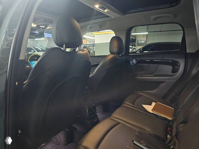 Вид на задние сиденья Mini Cooper Countryman 2022 через открытое заднее окно: пространство для пассажиров, подголовники и задняя обивка салона.