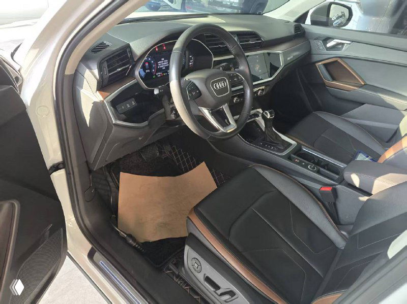 Внутренний вид салона Audi Q3: передние сиденья в кожаной отделке, пространство перед центра console, видны боковые панели и отделка сидений Fashion Elegance.