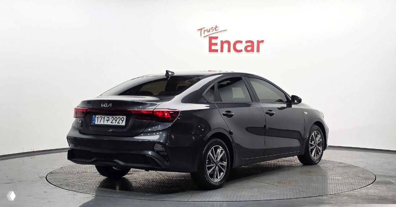 Задняя часть KIA K3 2021 серого цвета на поворотной площадке, видна задняя оптика, бампер и регистрационный номер в корейском формате.