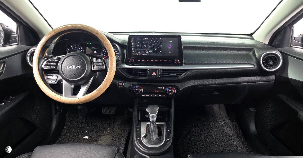 Интерьер KIA K3 2021: панорамный вид на руль с логотипом KIA, приборную панель и центральную консоль с экраном мультимедиа.