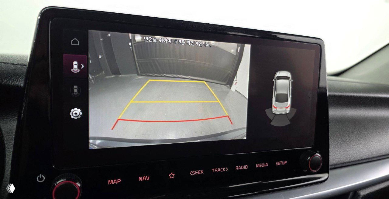 Экран мультимедиа с изображением камеры заднего вида и разметкой парковки в KIA K3 2021, показано состояние дисплея и интерфейса.