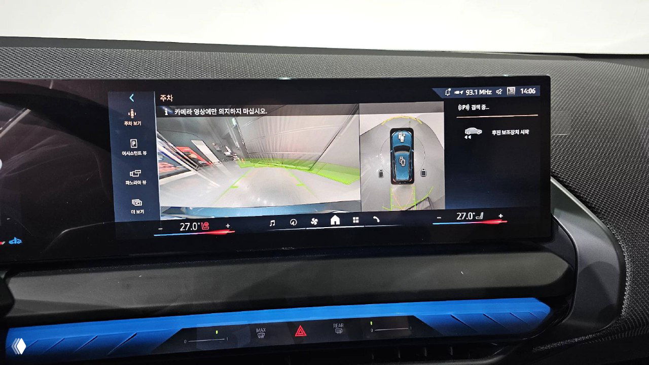 Крупный план центрального сенсорного дисплея BMW X3 с видом камеры и обзорной функцией парковки на экране мультимедиа.