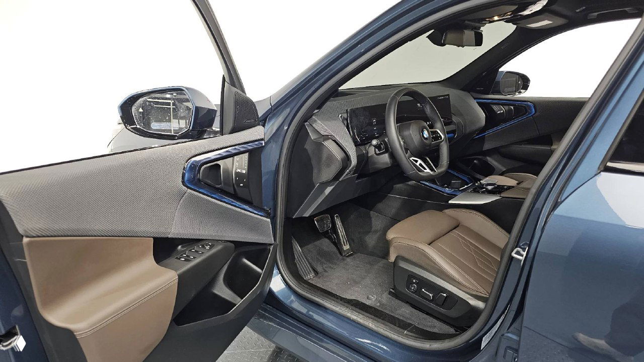 Открытая дверь водителя и вид на переднее кресло BMW X3: состояние обивки, регулировки сидения и элементы управления на двери.
