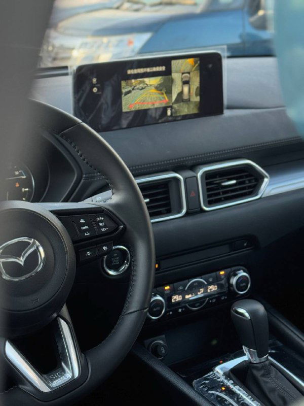 Интерьер Mazda CX-5 2025: центральная панель и экран мультимедиа, отображение вида с камеры, элементы управления на торпедо.