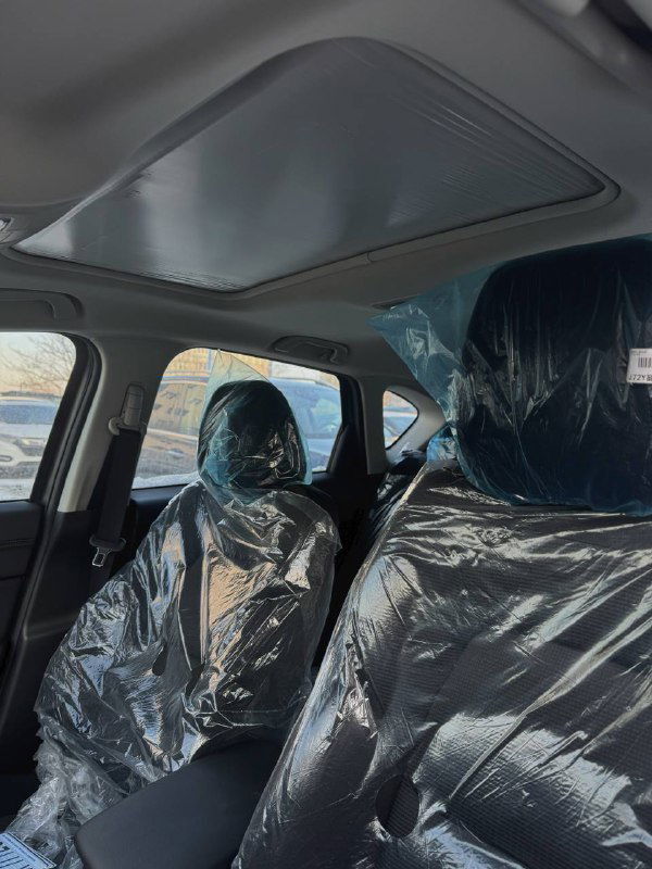 Панорамный люк и задняя часть салона Mazda CX-5 2025, сиденья покрыты упаковочной плёнкой, видна внутренняя отделка крыши и боковые стойки.