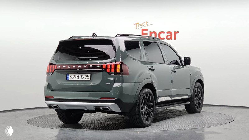 Задняя часть KIA Mohave того же необычного оттенка, видна светотехника, надпись MOHAVE и общий профиль внедорожника на белом фоне студии.