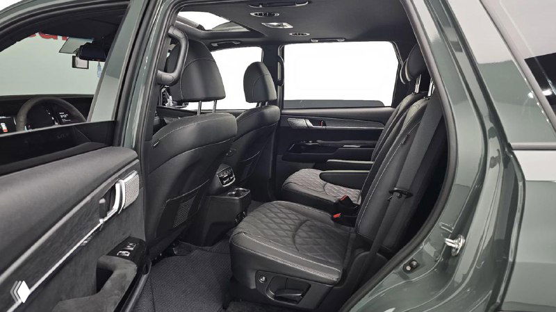 Второй ряд сидений KIA Mohave: три посадочных места, кресла с кожаной обивкой, простор салона и вид на центральный тоннель и подголовники.