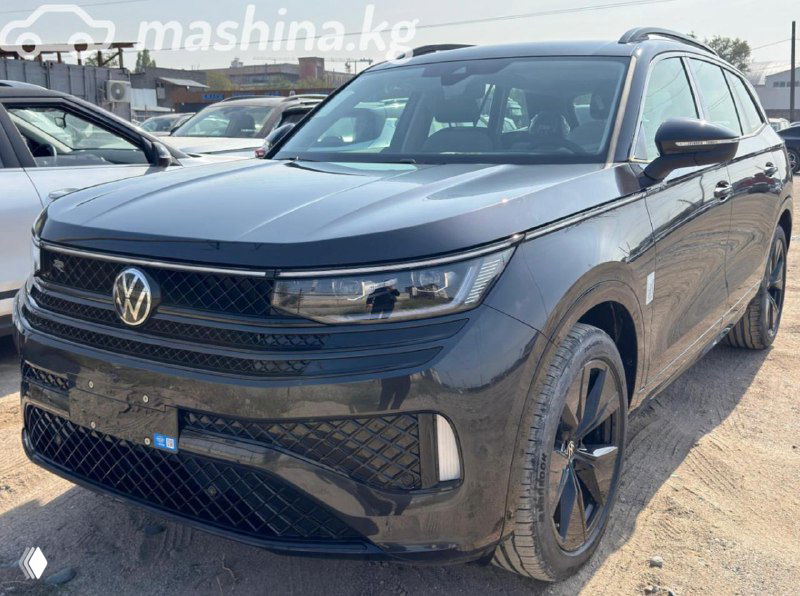 Тёмно-серый Volkswagen Tavendor R-Line на парковке торговой площадки — боковой ракурс, видны диски, кузов и дорожный просвет модели