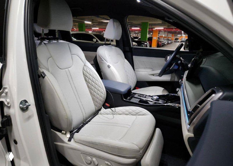 Передние кожаные сиденья KIA Sorento с декоративной прострочкой и регулировками, вид со стороны открытой двери для демонстрации состояния салона.